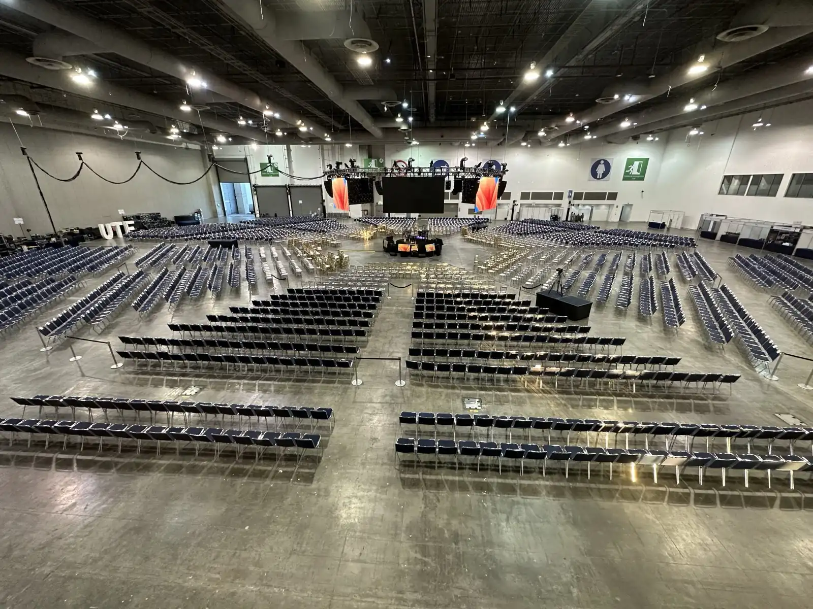 Montaje de un foro con escenario, pantallas y filas de butacas