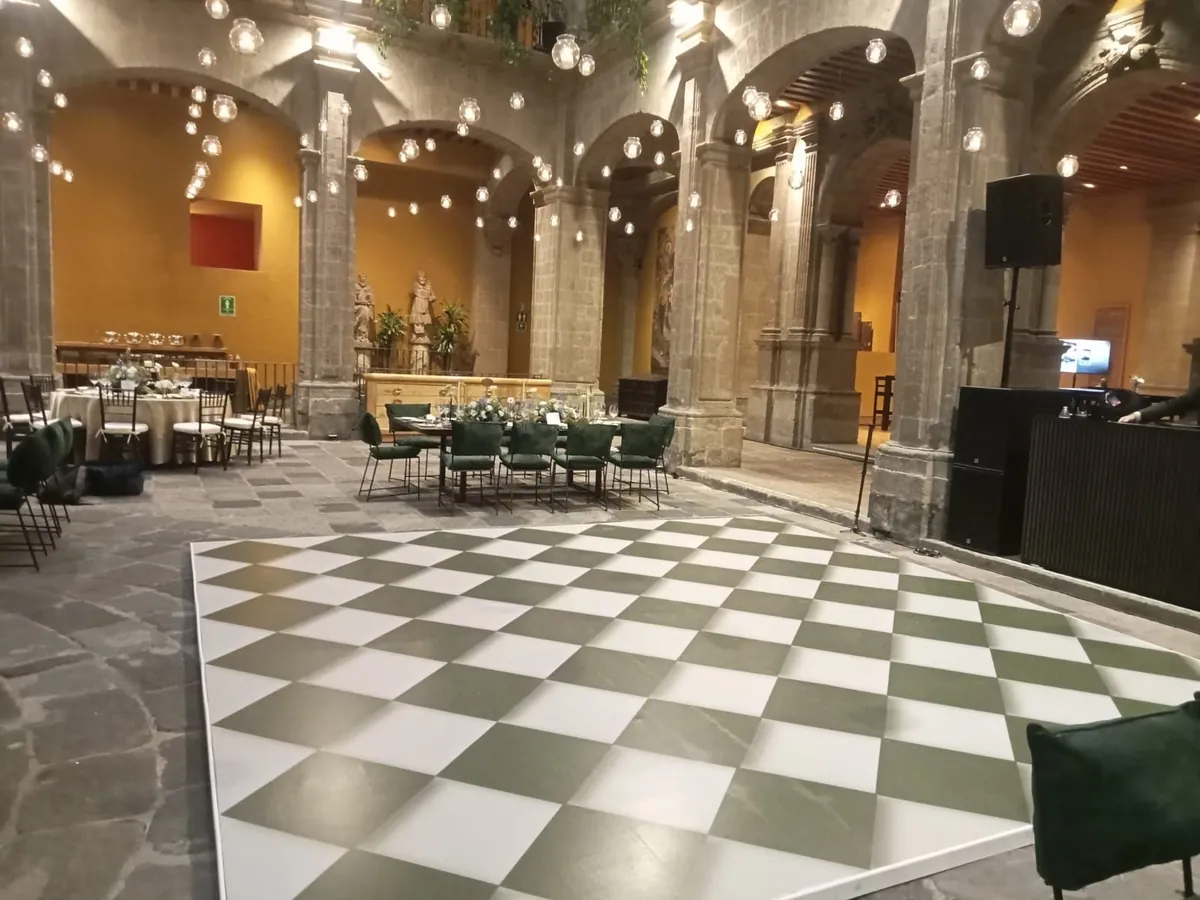 Patio histórico con pista de baile y luces colgantes.