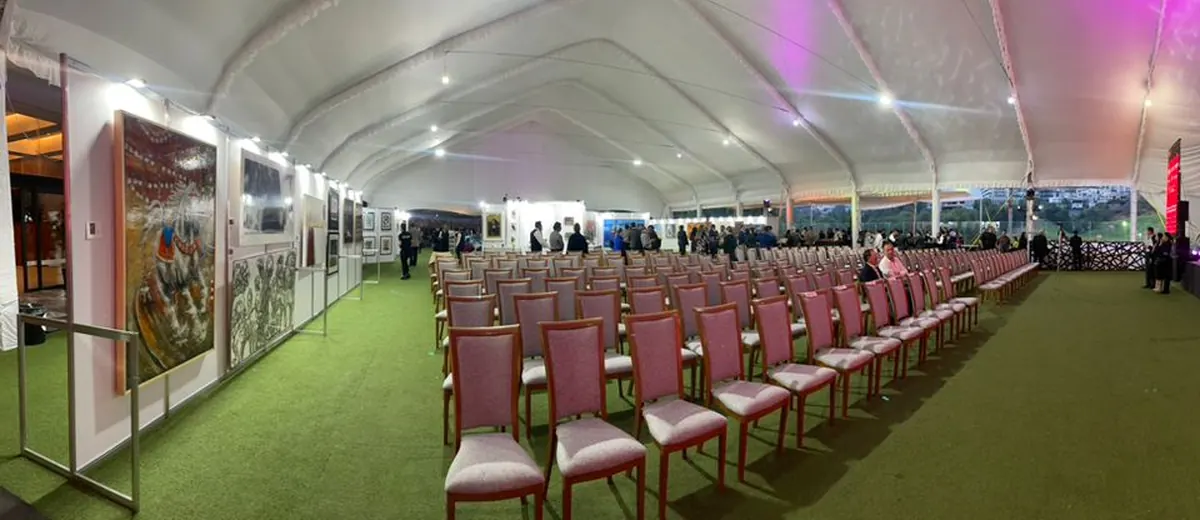 Galería bajo carpa, con obra colgada.